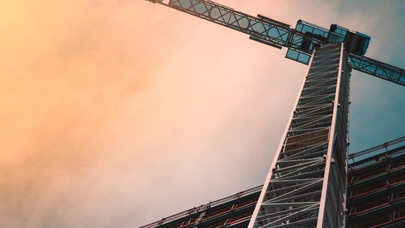 Ansicht auf einen Baukran von unten im Abendlicht